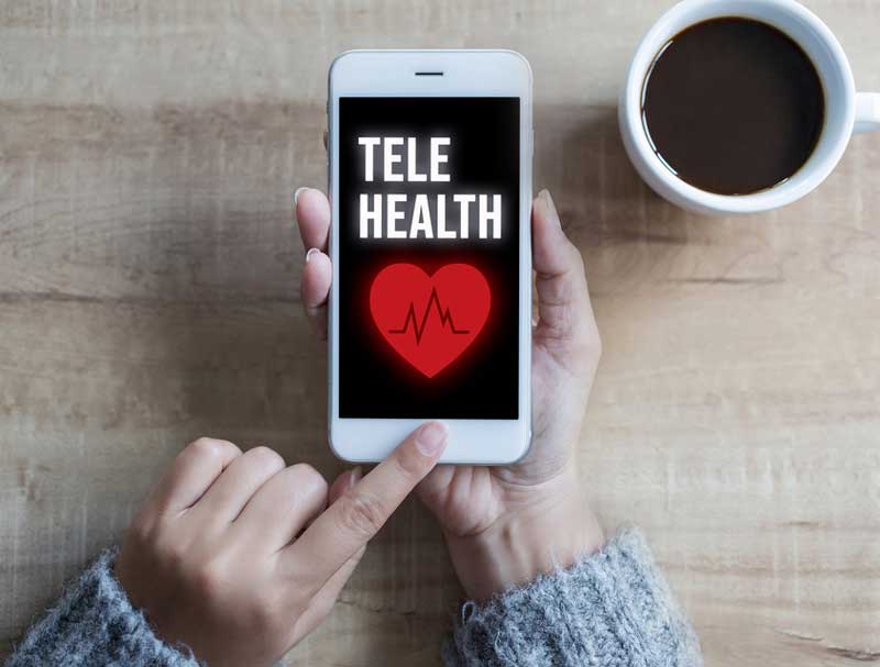 A woman ends a telehealth session on an iPhone by pressing the home button. woman ends telehealth session on iphone