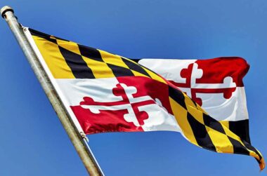 Maryland flag waving in a blue sky.
