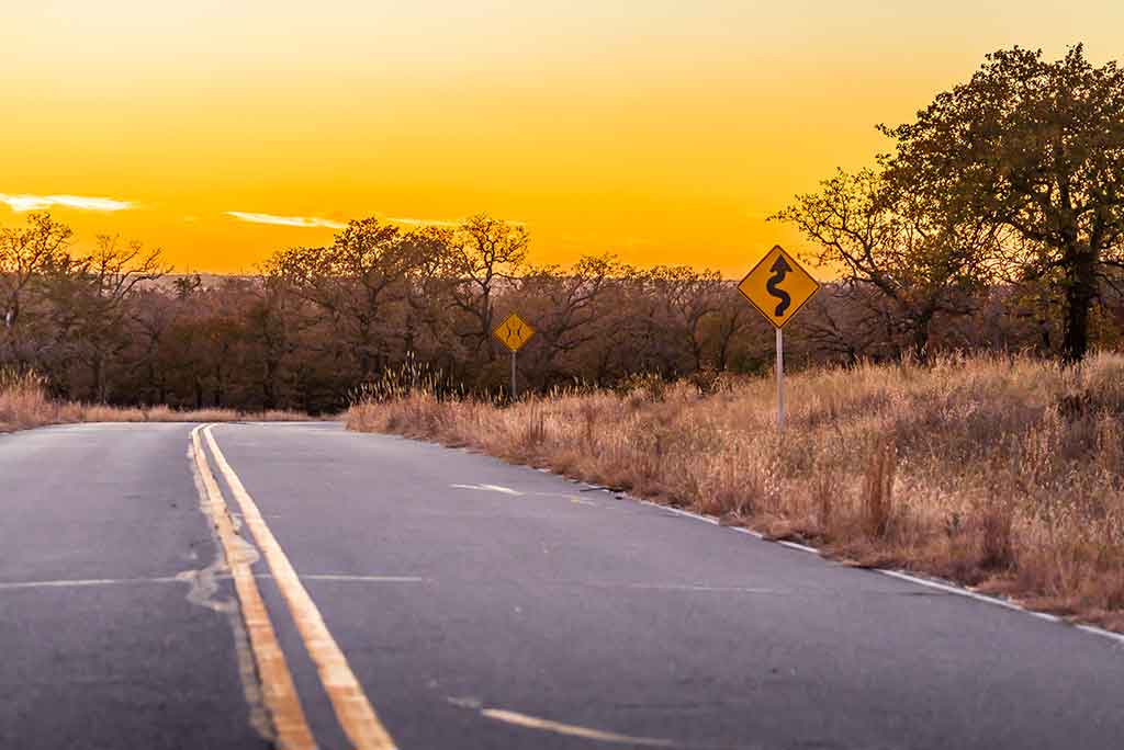 Oklahoma highway as the sun sets on the horizon.