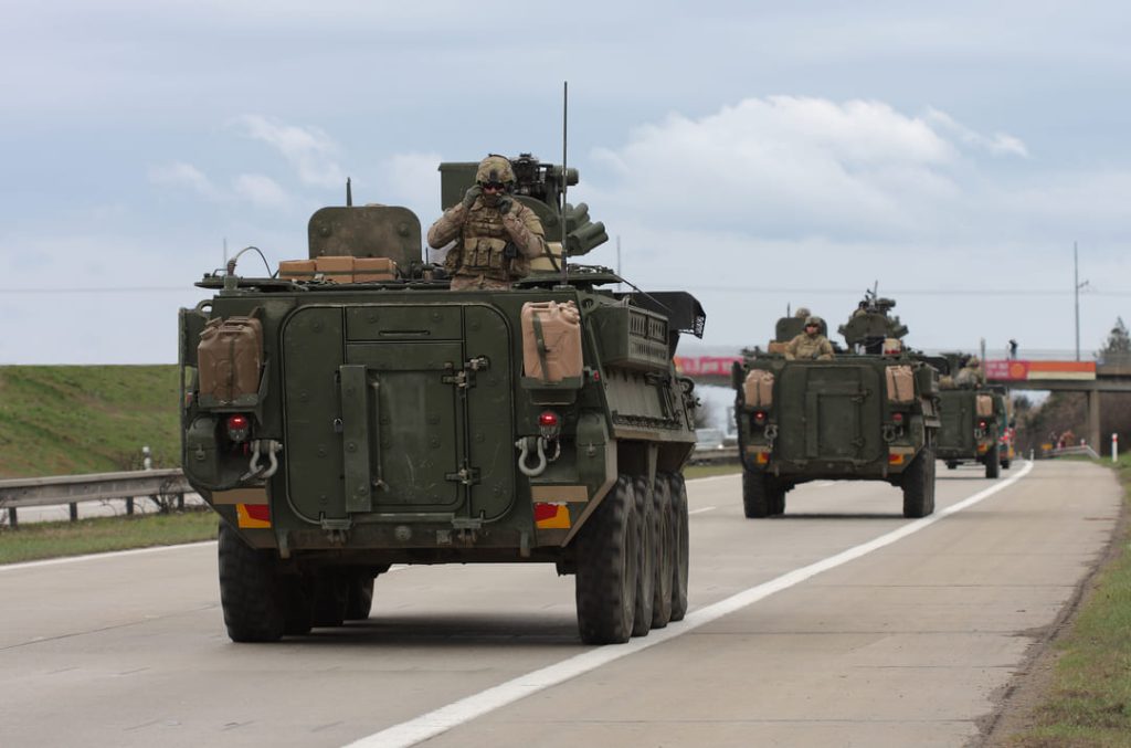 US Military Trucks carrying troops on highway.