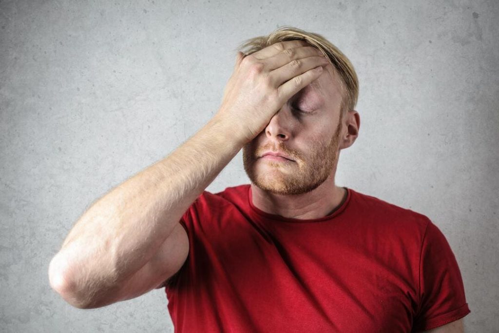 Man with hand on head in frustration or sadness.