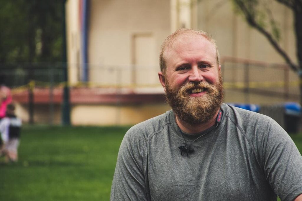 Man with beard smiling.