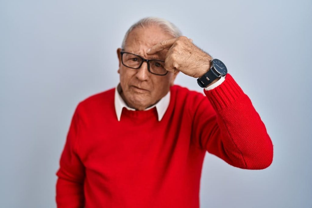 Man in red sweater pointing to his chloracne.