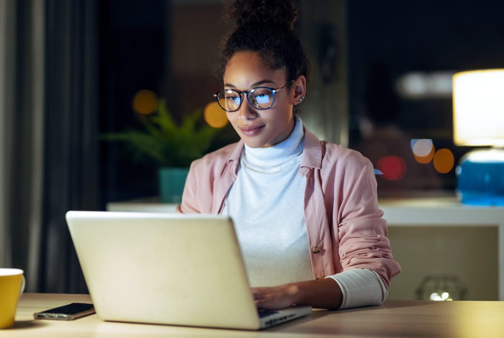 woman at laptop with reading glasses on.