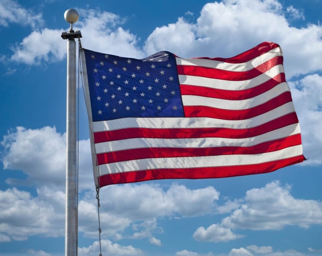American flag flying in a blue sky.