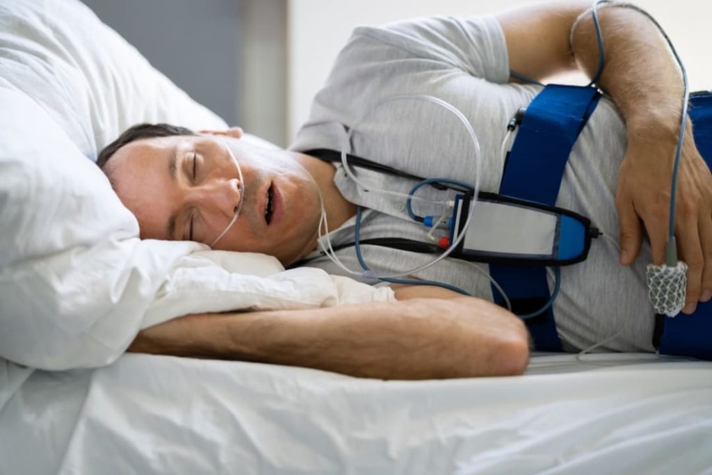 Man in bed wearing cpap machine.