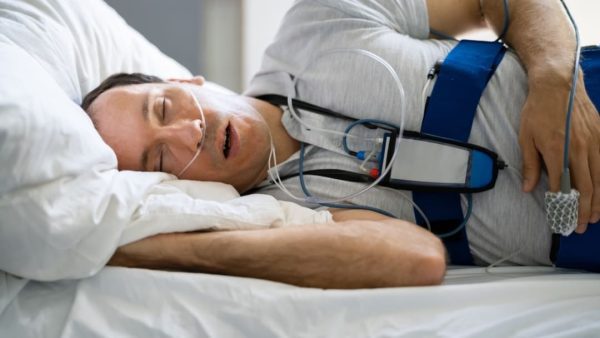 man in bed wearing cpap machine