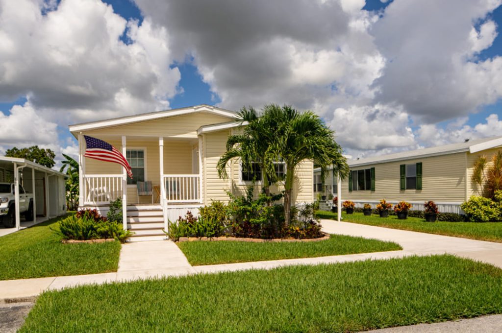 mobile home manufactured home with palm trees and US flag.