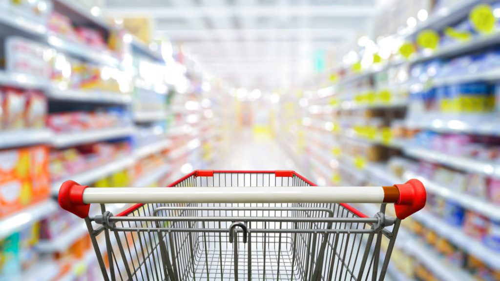 Grocery store cart in aisle.