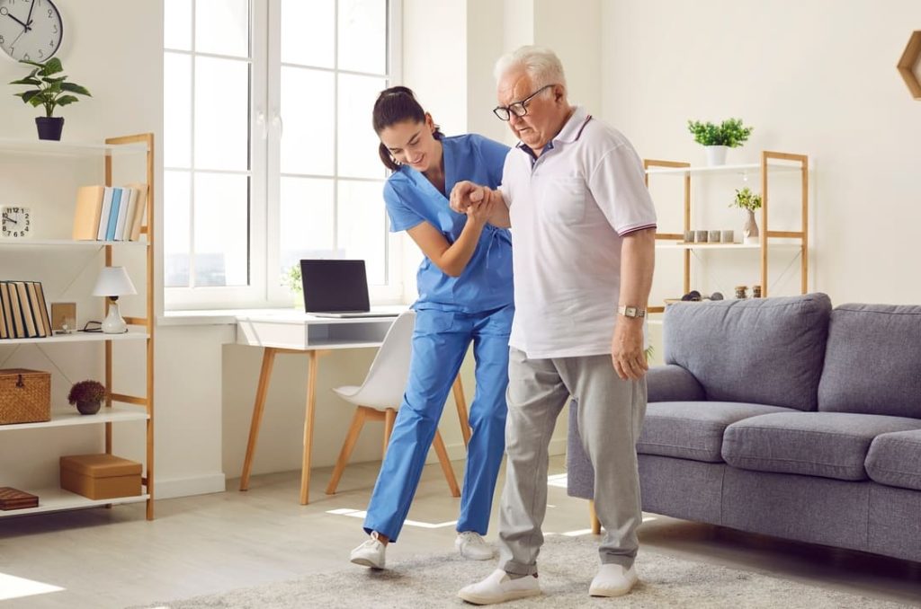 Female nurse helping older male veteran.