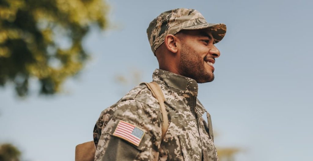 Young man in US military uniform, smiling.