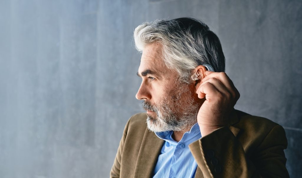 Grey haired,Mature,Man,With,Hearing,Impairment,Using,Hearing,Aid.,Hearing